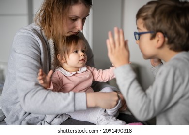 Small Caucasian Baby Getting Dressed Mother Young Woman Hold Her Child Daughter Girl While Dressing Her At Home Changing Clothes With Brother Boy Having Fun Real People Family Domestic Life Concept