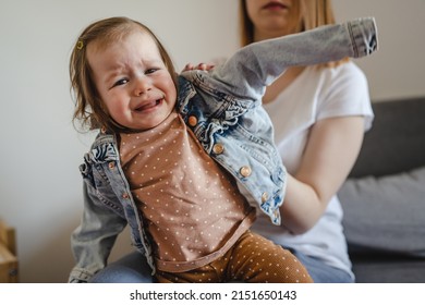 Small Caucasian Baby Girl Infant Child With Her Mother Dressing Undressing Small Daughter Crying Unhappy Frustrated At Home Childhood Parenthood And Growing Up Family Concept Real People Copy Space