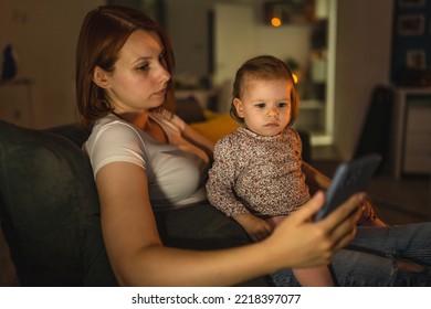 Small Caucasian Child Little Girl Toddler Mother And Daughter Sitting In Dark Room At Night At Home On Sofa Bed Watching Cartoons Or Movies On Mobile Phone Real People Family Growing Up Copy Space