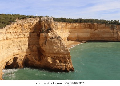 Small cave in limestone cliff by the Atlantic Ocean in southern Portugal on a sunny winter day along the Seven Hanging Valleys Trail.