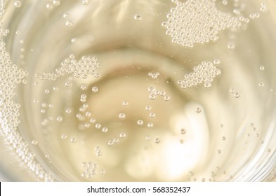 Small Champagne Bubbles In A Glass Of Champagne. Close Up. Texture Background