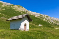 Small Chapel On The Green Alpine Meadow As Mountains On Background Near Colle Della Maddalena Mountain Pass In France.