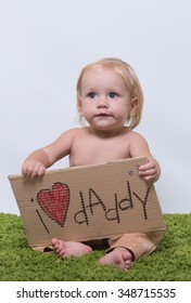 Small charming kid holding a sign "I love daddy!"