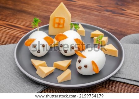 Small chicken eggs mouse,mice with ears of carrot,cheese on plate,creative, fun food,healthy lunch snack idea for kids party. Menu for spooky Halloween dessert treats, edible cute rat selective focus.