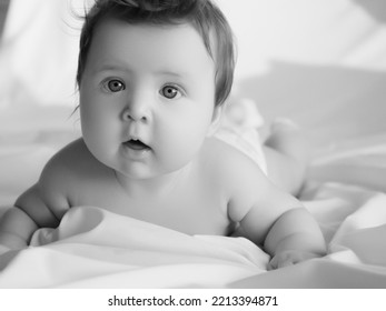 A Small Child Of 5 Months Lies On His Tummy And Controls The Muscles Of The Neck. Beauty And Health Of The Baby. Happy Baby And Mom. The Concept Of Motherhood