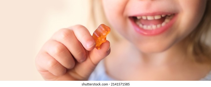 small child, blonde girl 3 years old wants to eat gelatinous sweets, gummy bear, kid has a good appetite, happy childhood, balanced diet, sweet life, unhealthy food, halal food