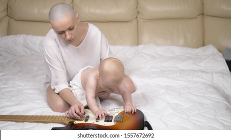 Small Child Boy And His Mom Are Playing Electric Guitar.