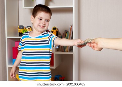 A Small Child Boy Takes Dollar Bills From The Hands Of An Adult Parent. Financial Literacy In Children And Pocket Money