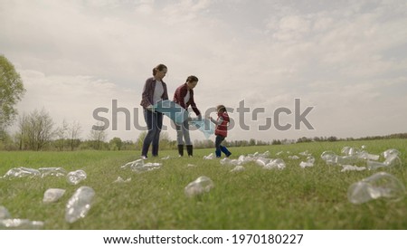 A small child collects trash with his family, protecting the environment from pollution, volunteering a group of people in a team, making the planet cleaner, plastic garbage, cleaning the environment.