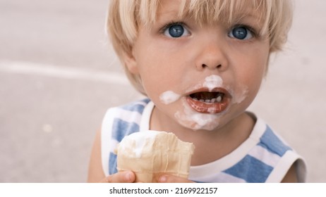 A Small Child Eats White Ice Cream With Great Pleasure Ice Cream On Face