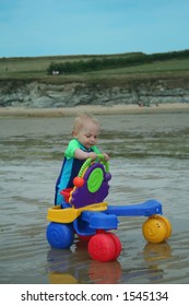 Small child exploring a beach in Cornwall.