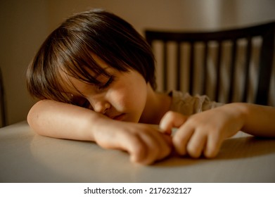 A Small Child Fell Asleep After Eating At The Table. Asian Three Year Old Boy Is Tired. Shallow Depth Of Field (DOF)