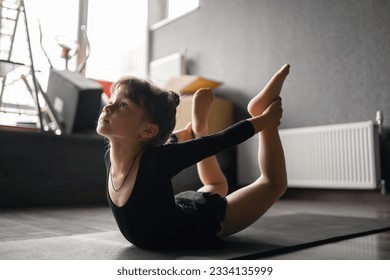 Small child girl doing stretching exercises Bow pose, gymnastic and dancing training class. - Powered by Shutterstock