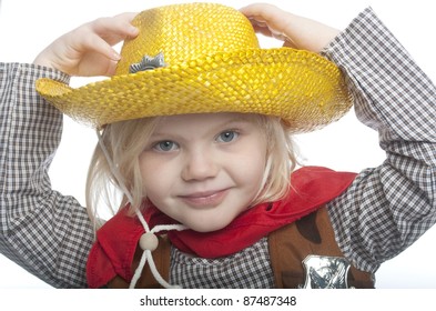 Small Child Is Holding Her Yellow Had. The Child Is Dressed In A Cowgirl Costume