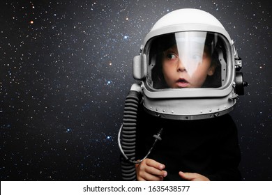 A Small Child Imagines Himself To Be An Astronaut In An Astronaut's Helmet. Elements Of This Image Furnished By NASA