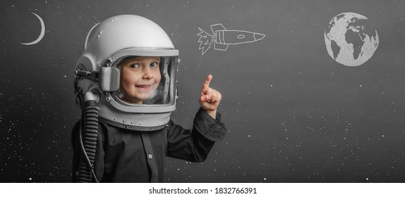 A Small Child Imagines Himself To Be An Astronaut In An Astronaut's Helmet. 