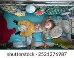 A small child lies soundly asleep in a crib, nestled among soft blankets and plush toys, radiating innocence and warmth in a tranquil afternoon setting.