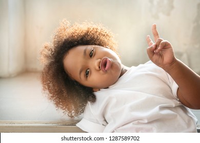 Small Child Little Girl Curly Hair Raised Two Fingers Up. 2 Thumbs Up Is A Symbol Of Victory.  