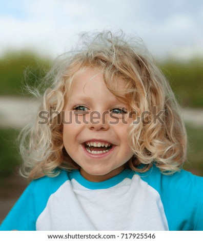 Small child with long blond hair enjoying of a sunny day