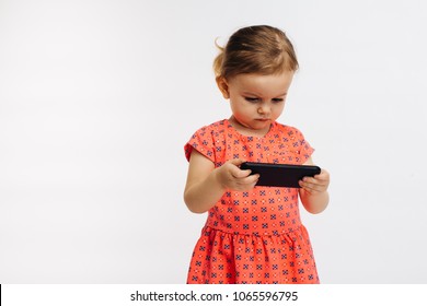 Small child looking at cell phone, isolated on white studio background