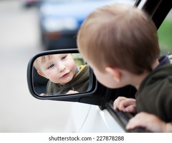 Small Child Looking To Outside Mirror