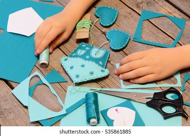 Small Child Made A House With Hearts Ornament Of Felt. Materials And Tools For Making Felt Ornaments. How To Teach Child To Hand Sew. Simple Lesson Sewing