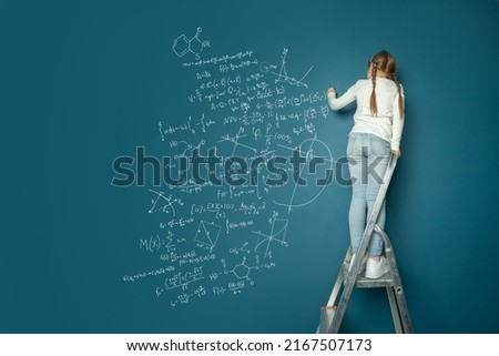 Small child math student writing science formulas on blue background