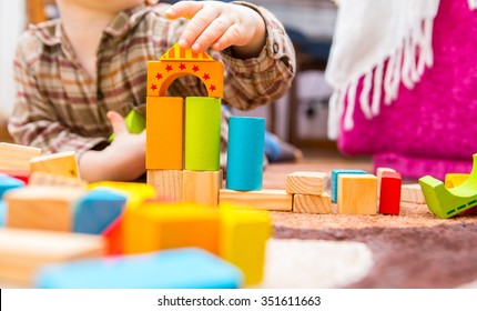 Small Child Playing With Wooden Blocks. Caucasian Boy Building With Blocks