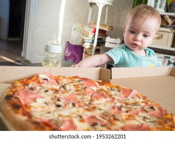 A Small Child Reaches For A Slice Of Pizza