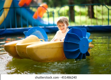 Small Child Rides On A Small Catamaran In The Pool