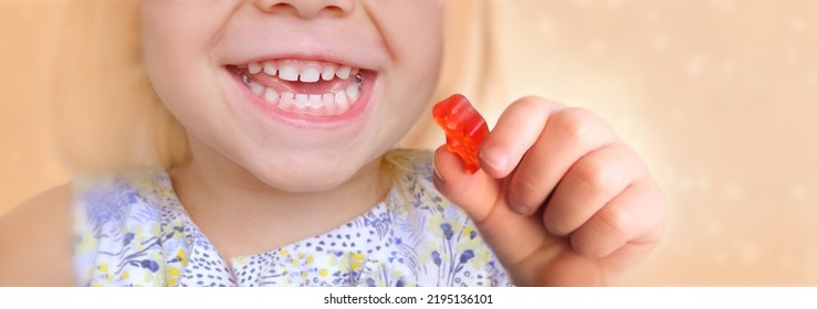 small child smiles openly, blonde girl 3 years old wants to eat gelatinous sweets, gummy bear, kid has a good appetite, happy childhood, balanced diet, sweet life, unhealthy food, halal food - Powered by Shutterstock