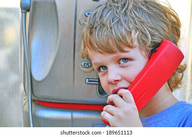 Small Child Talking By Public Phone