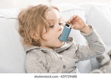 Small Child Using His Inhaler Device For Asthma