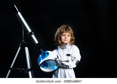 Small Child Wants To Fly An In Space, Kid Boy With Telescope Wearing An Astronaut Helmet. Copy Space. Success, Creative And Start Up Concept.