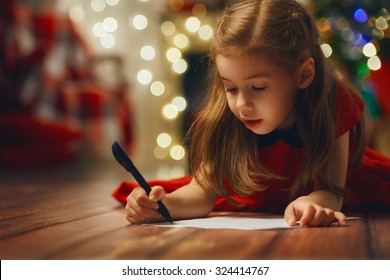 small child writes the letter to Santa