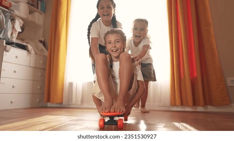 small children play at home and ride skateboard. happy family childhood dream concept. a group of little kids having fun together at home in a bright room. children smiling and lifestyle laughing - Powered by Shutterstock