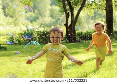 Small children play with soap bubbles in the summer outdoors.