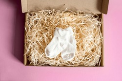 Kleine, Weiße Socken Für Kinder In Einer Handwerklichen Schachtel Auf Rosafarbenem Hintergrund. Universal Socken Für Jungen Und Mädchen.
