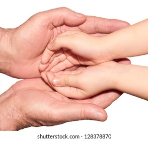 Small child's hand in the large  palms of an adult
