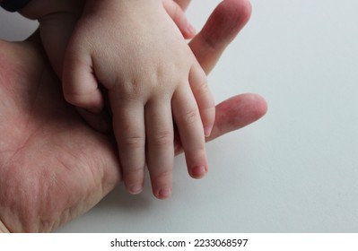 Small child's hand in the open palm hand of an adult human isolated stock photo 
				