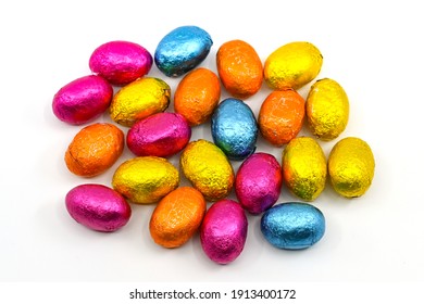 Small Chocolate Eggs In Coloured Foil Wrappings On A Plain Background. No People.