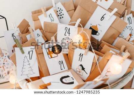 Small Christmas gifts in Advent calendar waiting for Christmas. Basket with envelopes with numbers and tasks for children. Seasonal tradition