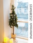 small Christmas tree in a pot on the window