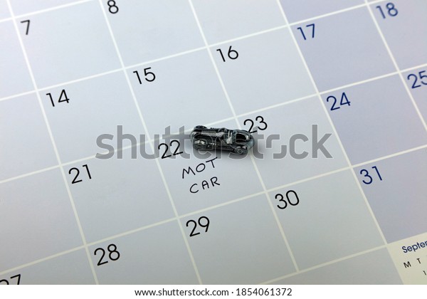 A Small Chrome Model Car On A Calendar Showing A
Cars MOT Date.
