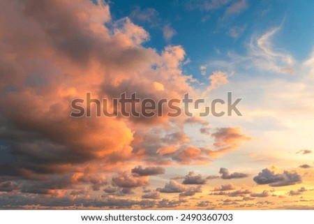 Small clouds in dramatic real sky at sunset texture background overlay. Dramatic blue, orange, and purple clouds. High resolution photograph perfect for sky replacement
