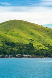 A Small Coastal Island Village And A Small Grass Covered Hill Right In Front Of The Ocean. 