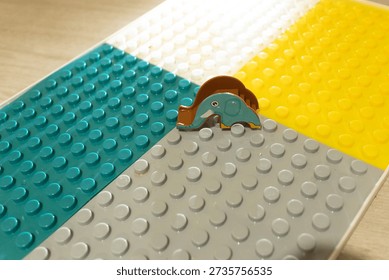 Small colored blocks are arranged in sections. A plastic elephant figure stands in the middle. This scene shows a playful setting for creative building and imagination.