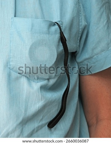 Small compact point and shoot digital camera. In a mans short sleeve shirt pocket. Illustrates portability, convenience and discretion for everyday carry around photography. Hobby or pastime