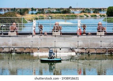 Small Concrete Dam Separates The Wastewater Treatment Facility Oxydation Ponds. The Pumps For Water Contaminated Water Aerating And Filtering