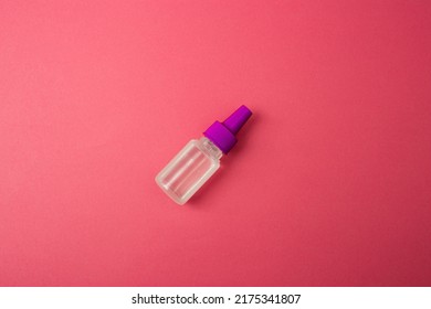 A Small Cosmetic Bottle On A Pink Background